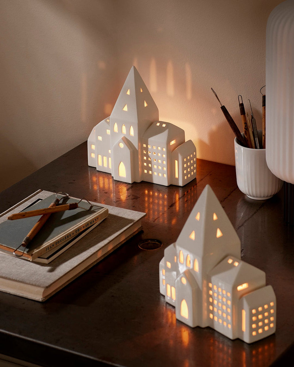 โคมเทียนเซรามิก Kähler Urbania รูปบ้านสีขาว ช่องหน้าต่างเจาะมือ ให้แสงอบอุ่นผ่านช่องหน้าต่าง เติมบรรยากาศอบอุ่นในบ้าน งานออกแบบเดนมาร์กสไตล์มินิมอล จัดจำหน่ายโดย Old Pine Trees