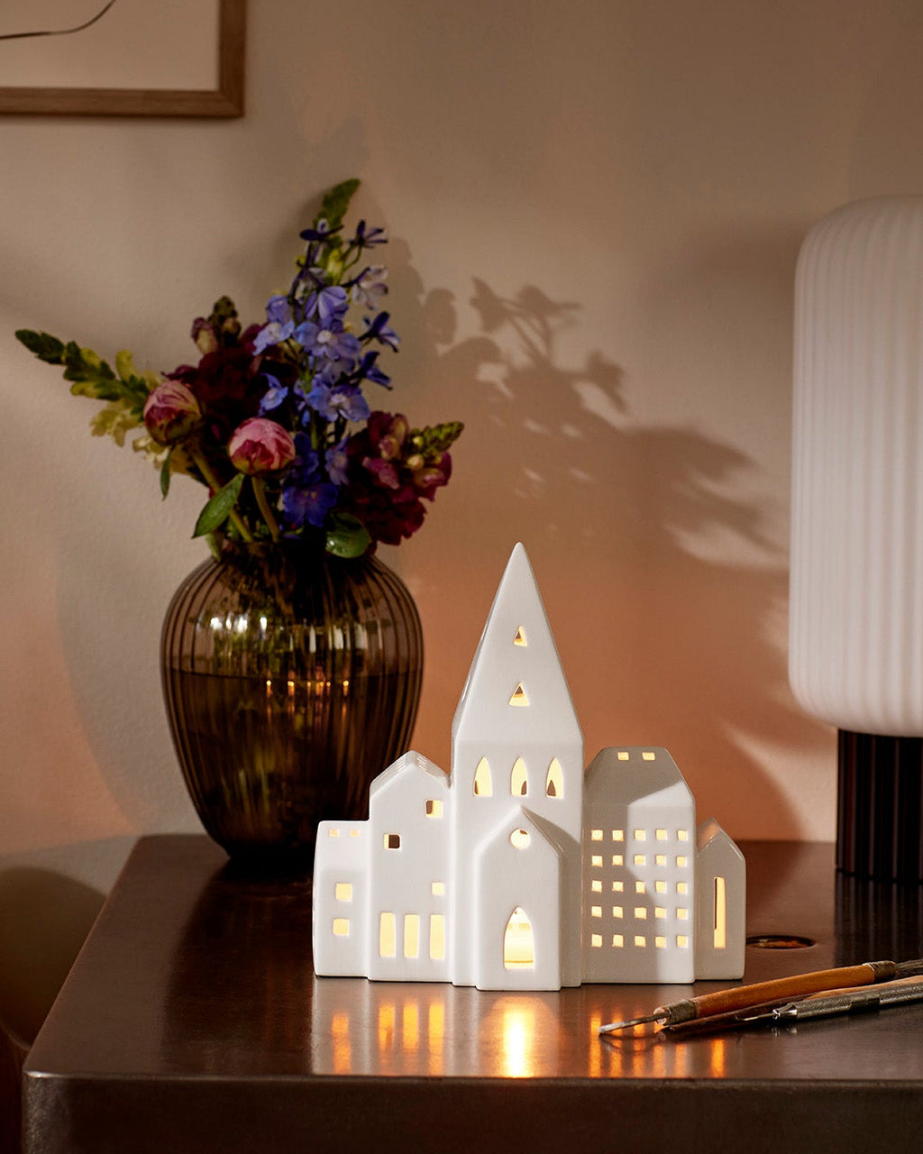 โคมเทียนเซรามิก Kähler Urbania รูปบ้านสีขาว ช่องหน้าต่างเจาะมือ ให้แสงอบอุ่นผ่านช่องหน้าต่าง เติมบรรยากาศอบอุ่นในบ้าน งานออกแบบเดนมาร์กสไตล์มินิมอล จัดจำหน่ายโดย Old Pine Trees