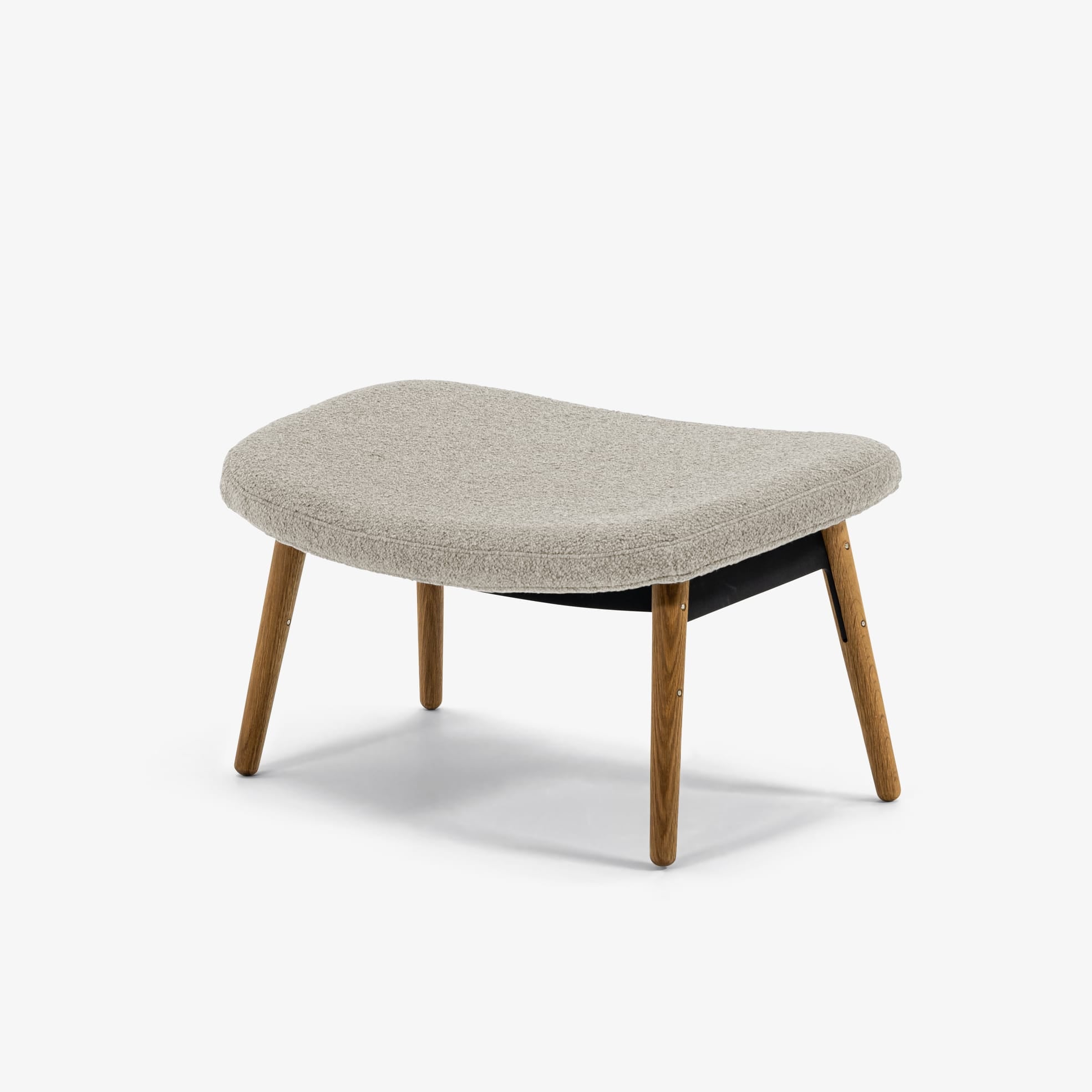 Case Furniture Ella Ottoman สตูลพักเท้าทรงโมเดิร์น หุ้มผ้า Bouclé เนื้อนุ่ม พร้อมฐานให้เลือก 4 แบบ ทั้งเหล็กดำ สเตนเลส ไม้โอ๊ค และไม้วัลนัต ออกแบบโดย Matthew Hilton ใช้คู่กับ Ella Lounge Chair