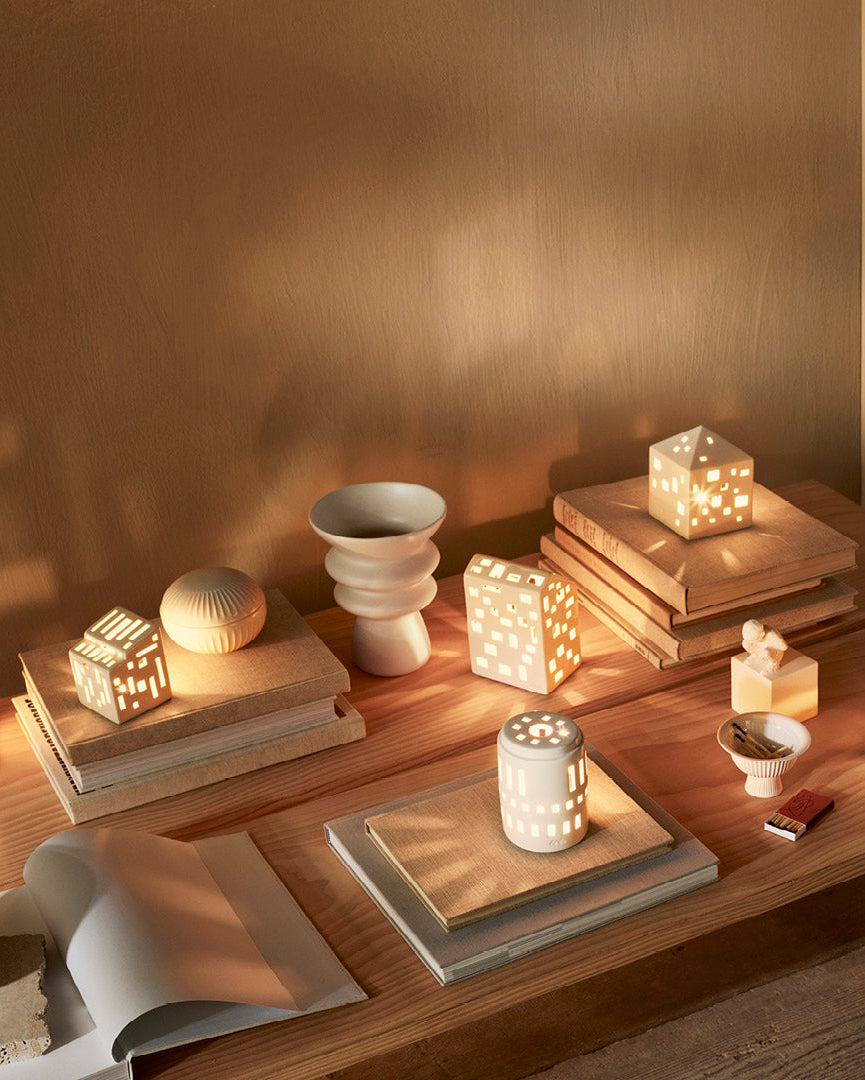 โคมเทียนเซรามิก Kähler Urbania รูปบ้านสีขาว ช่องหน้าต่างเจาะมือ ให้แสงอบอุ่นผ่านช่องหน้าต่าง เติมบรรยากาศอบอุ่นในบ้าน งานออกแบบเดนมาร์กสไตล์มินิมอล จัดจำหน่ายโดย Old Pine Trees