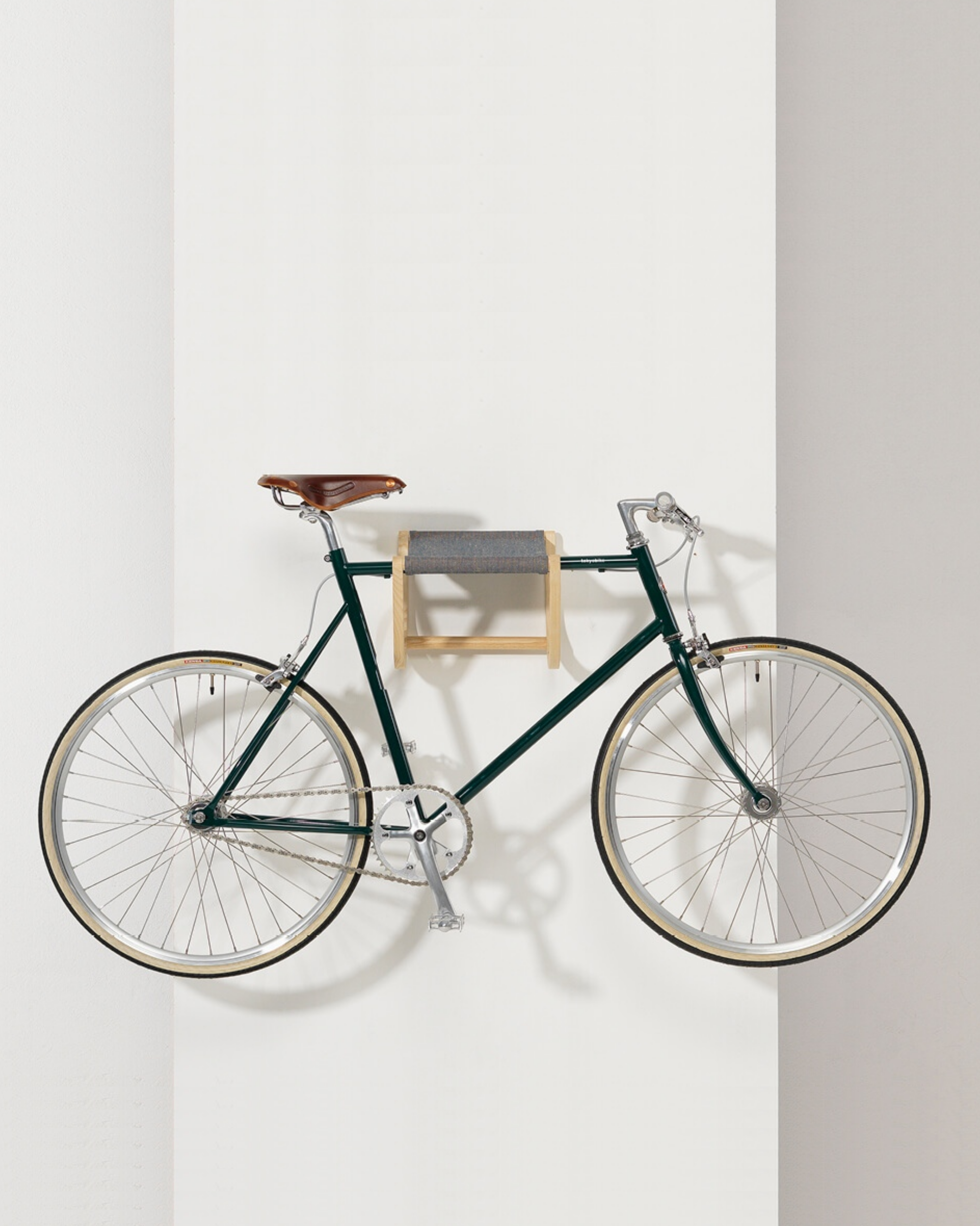 René Bicycle Rack ที่แขวนจักรยานติดผนังจาก ash พร้อม fabric sling สำหรับแขวนหมวก เสื้อผ้า และของใช้ ออกแบบโดย Tomoko Azumi